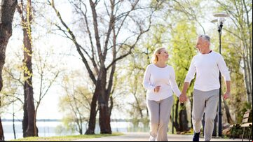 Romantic feelings. Nice aged couple holding hands while jogging together in the park. Foto: Viacheslav Yakobchuk/Adobe Stock
